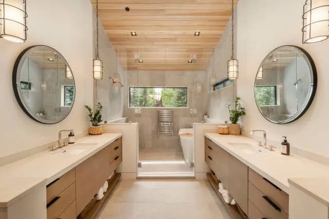 Luxurious modern master bathroom featuring a seamless curbless walk-in shower and elegant vanity, combining high-end design with aging-in-place accessibility.